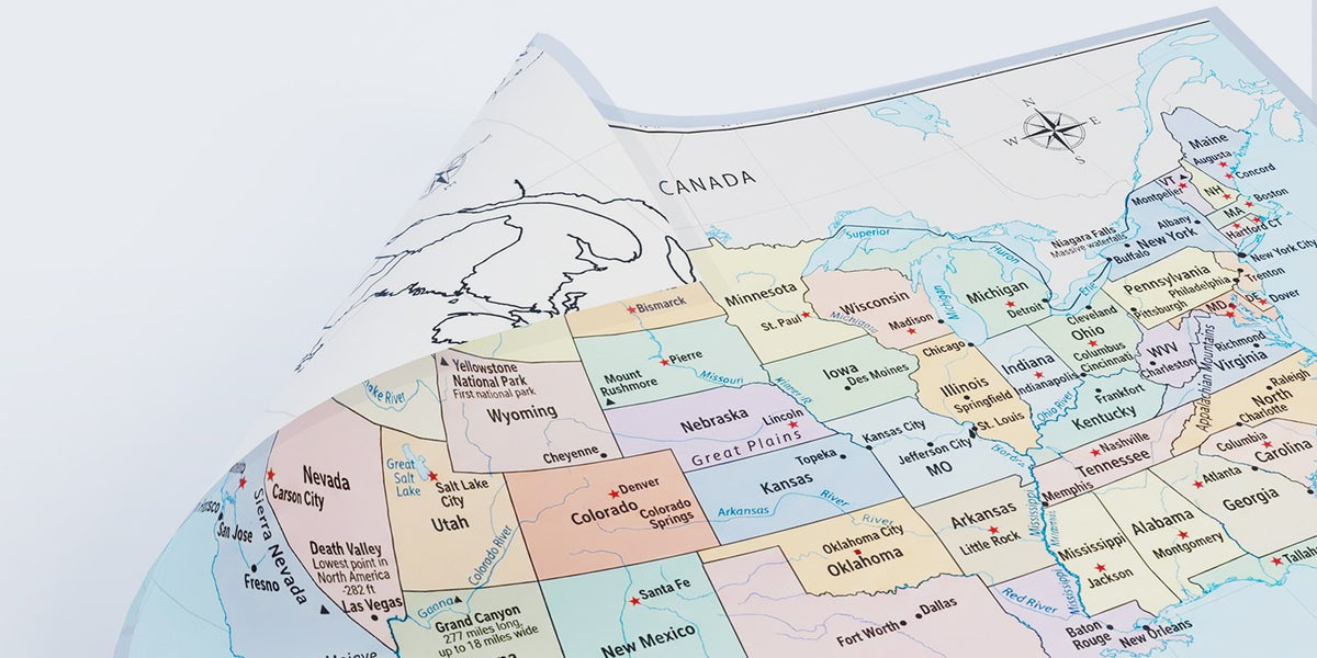 Close-up of a laminated United States map poster showing states, capitals, rivers and national parks
